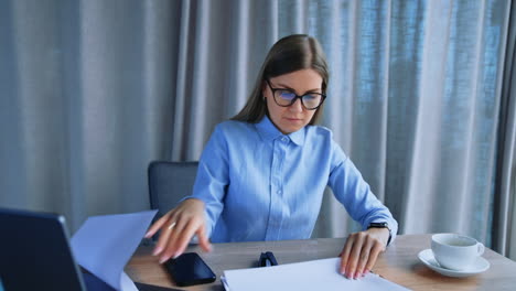 blonde woman looking for a necessary document turning the pages. busy business lady at work in the office.