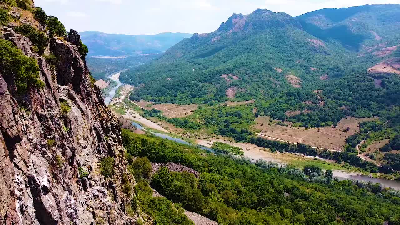 협곡 강과 먼 거리의 산들을 볼 수 있는 바위 산으로 비행