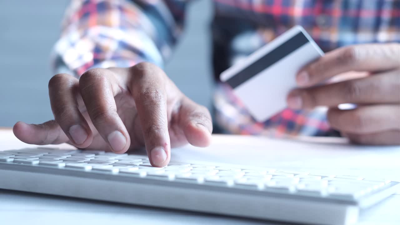 Person using a credit card and keyboard to make an online purchase