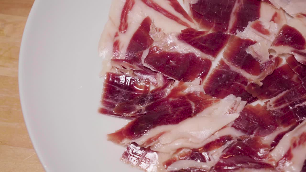 jamón ibérico español en plato blanco, primer plano a la izquierda para copiar espacio