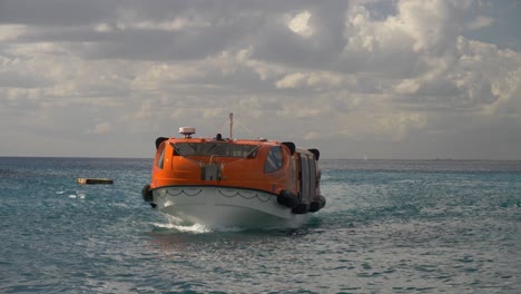 an orange tender boat approaches isla catalina, dominican republic on a sunny day