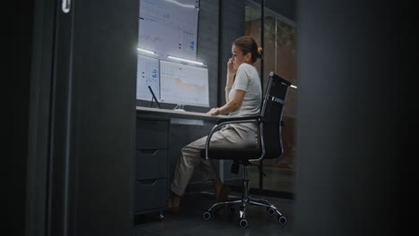 female financial analyst talking on phone, analyzing exchange market charts on multi-monitor computer and tablet, suffering from financial crisis. businesswoman stressed about stock market collapse.