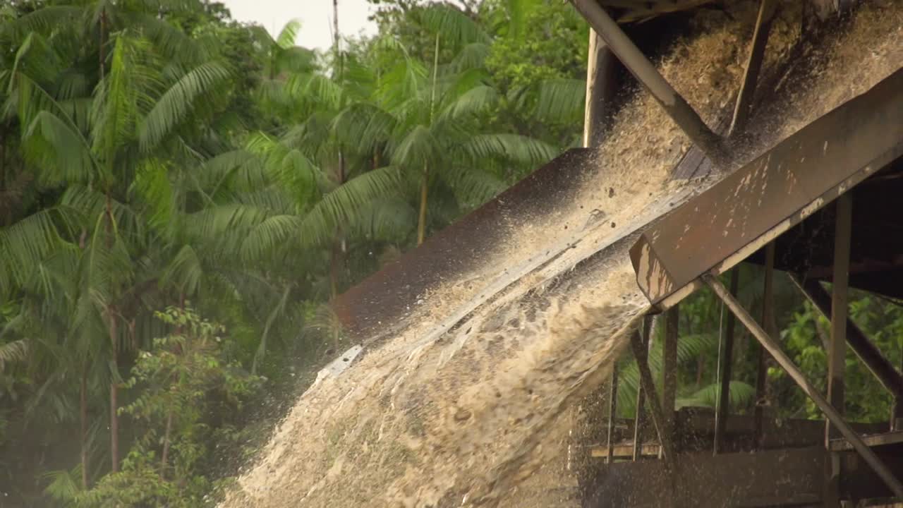 Sabbia e fango trattati che fuoriescono da una draga d'oro nel fiume a Checo, Colombia-3