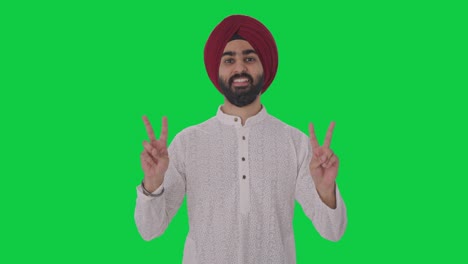 happy sikh indian man showing victory sign green screen