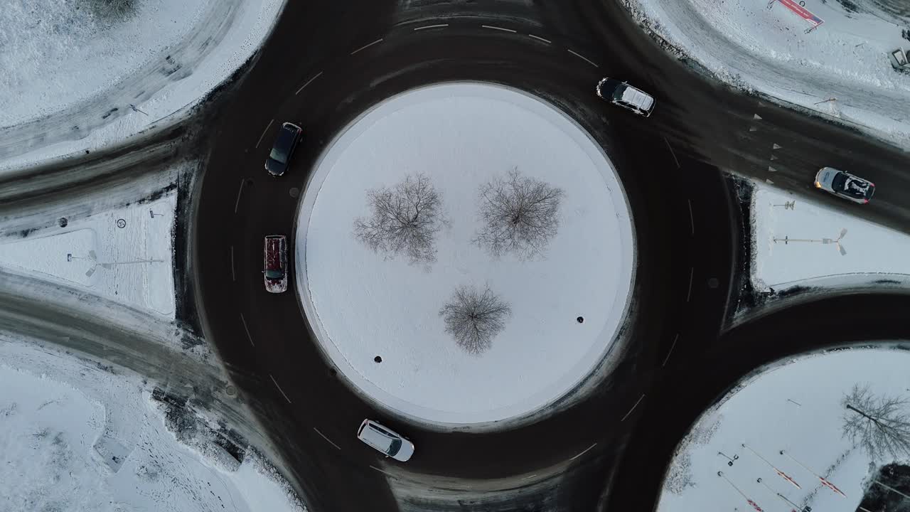 Roundabout in the snow, aerial view, cars driving, Sweden, winter weather