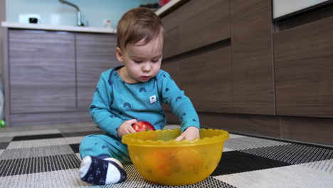 baby eating an apple in the kitchen
