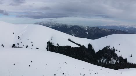 Serene-snow-covered-Piatra-Craiului-Mountains-seen-from-Iezer-Papusa,-Romania,-with-cloudy-skies