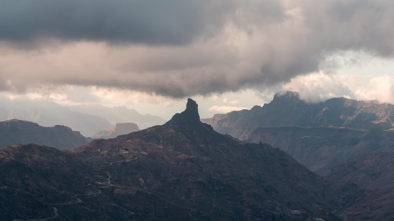 Epic timelapse of Roque Bentayga under shifting clouds in Gran Canaria. The rugged volcanic landscape creates a mystical and cinematic scene. Ideal for nature, travel, and adventure projects.