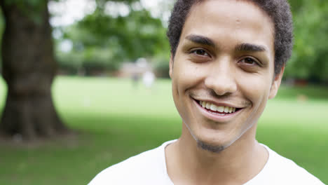 Close-up-portrait-happy-young-mixed-race-man-smiling-at-camera