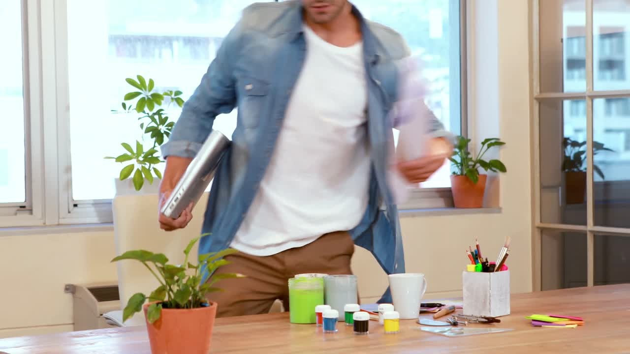 hombre de negocios casual dejando la oficina y sosteniendo una computadora portátil y papel