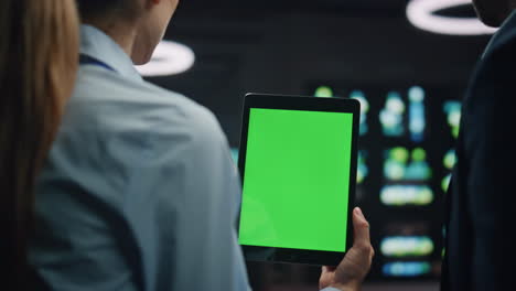 los ingenieros de it que utilizan la tableta chroma key están investigando la red en el centro de datos.