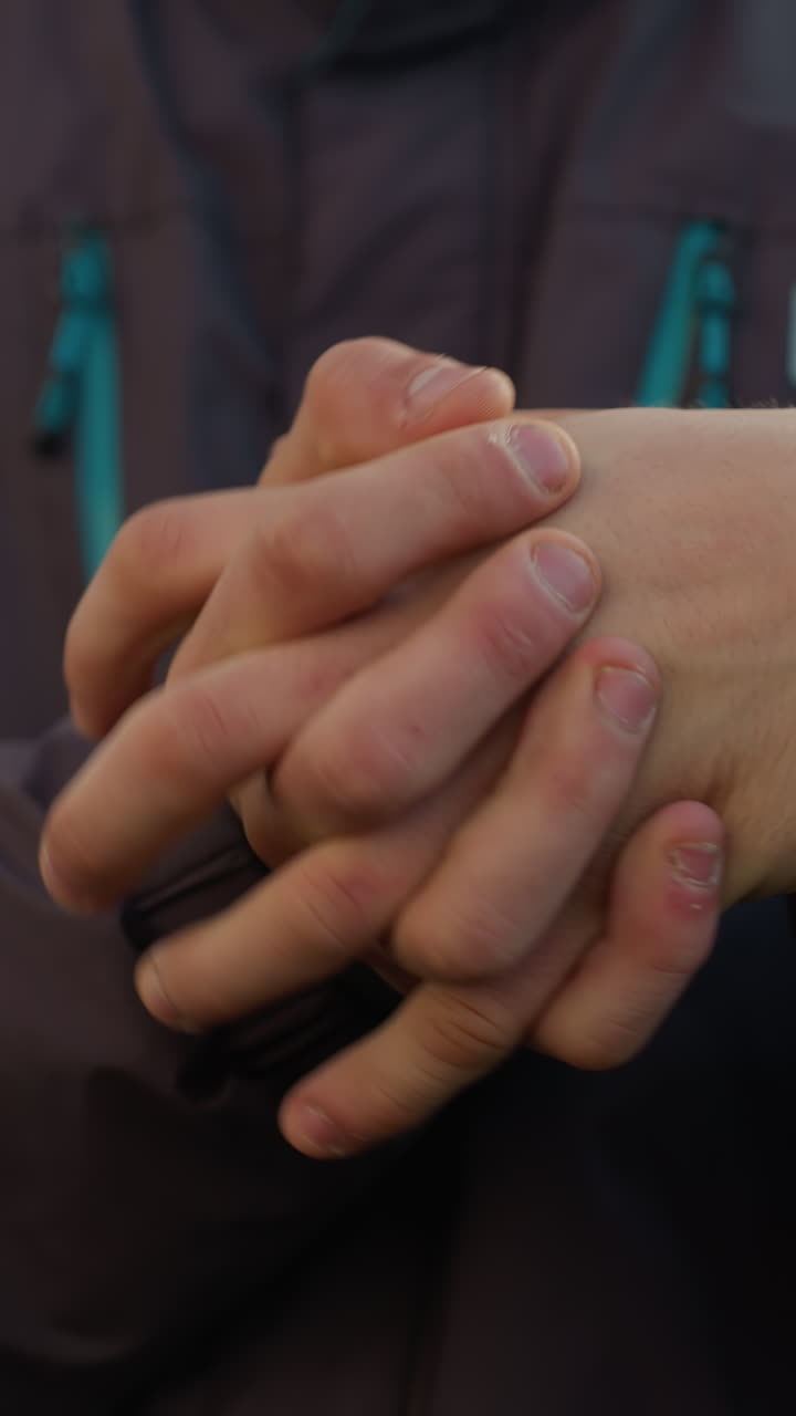 primer plano de manos estrechamente unidas en un gesto reflexivo y contemplativo, centrarse en la textura natural de la piel, con iluminación suave y fondo borroso de edificios urbanos