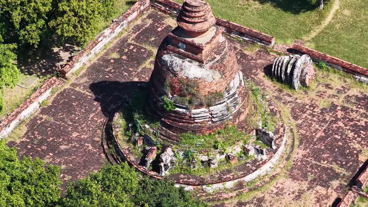 Una vista dettagliata dall'alto di un chedi in mattoni logorato circondato da alberi verdi lussureggianti