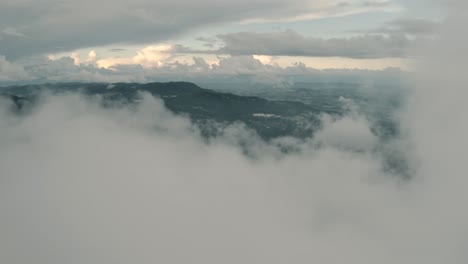 Drone-aerial-view-panning-around-clouds-in-a-misty-beautiful-landscape