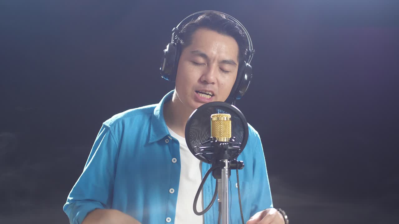 녹음 스튜디오 에서 마이크 로 노래 하는 남자