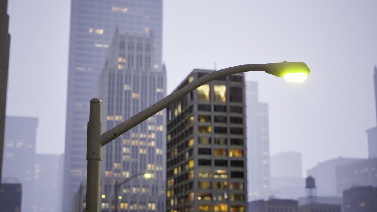 Foggy evening in a city with buildings lit by streetlights
