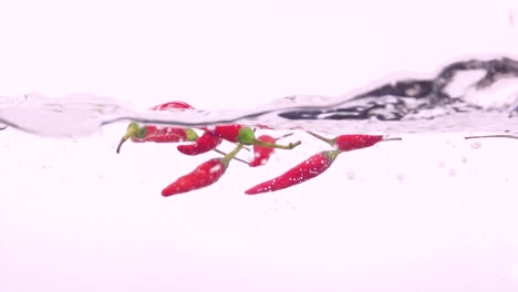 red chili peppers falling into water