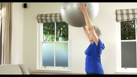 senior woman lifting exercise ball