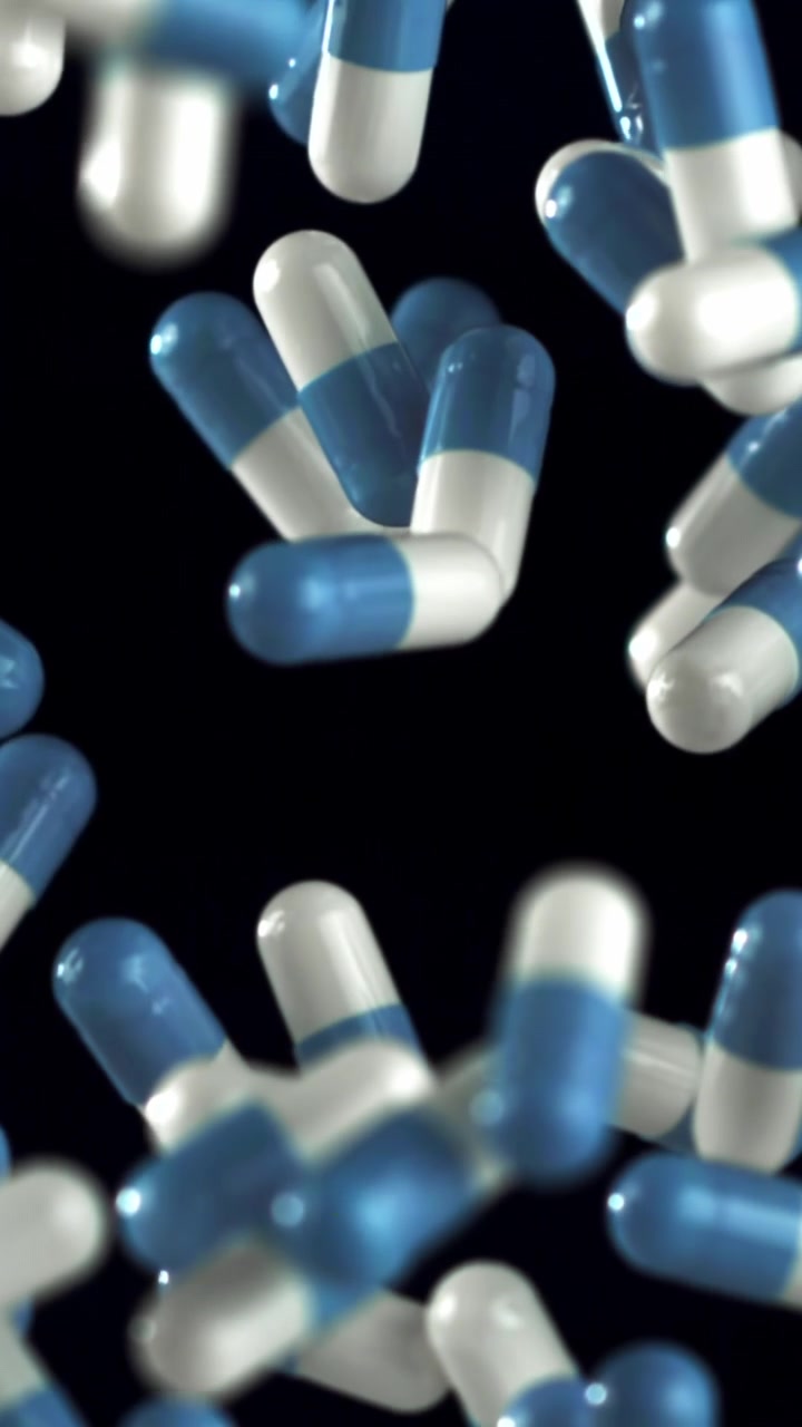 Capsule mediche blu e bianche che cadono al rallentatore