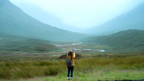 woman hiking in misty scottish highlands