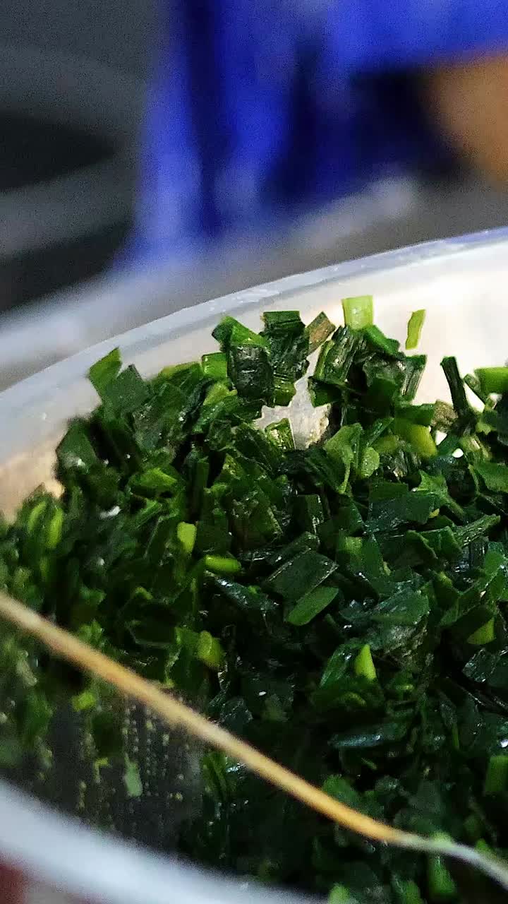 manos mezclando y exprimiendo espinacas en un cuenco