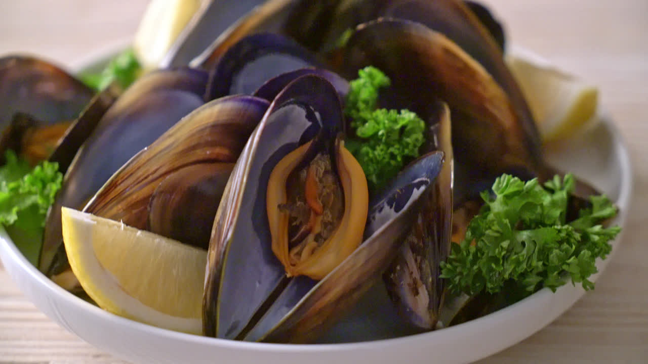 레몬 그릇에 허브와 함께 신선한 홍합