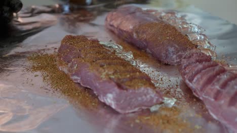 un chef rocía condimentos en los estantes de cordero con especias secas listas para la barbacoa