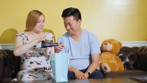 a pregnant woman with her husband looks at just that things bought for the baby expecting a baby buy