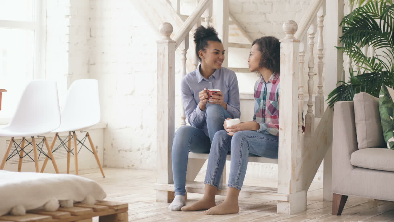 Two young women having a conversation on the stairs