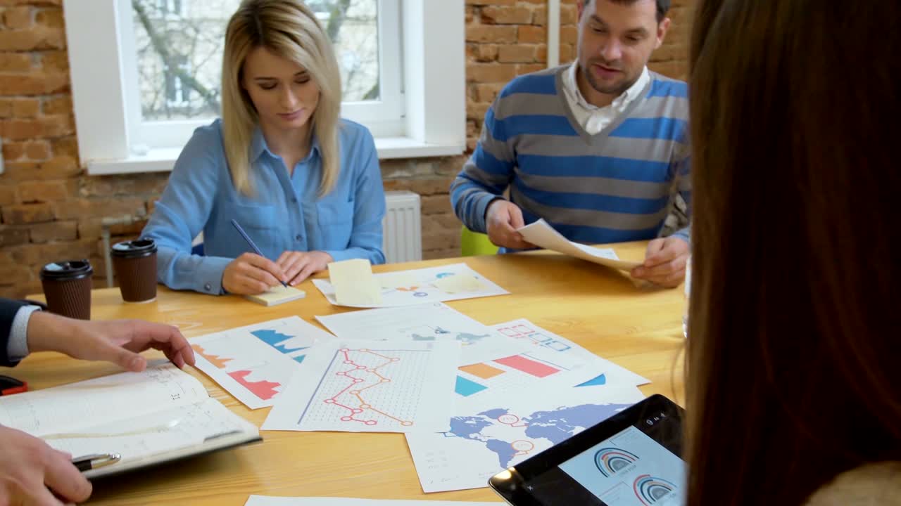 reunión de equipo de negocios involucró a diversas personas que participaron en ideas creativas y sostenibles steadicam filmado a través de la mesa de la sala de juntas espacio de trabajo compartido