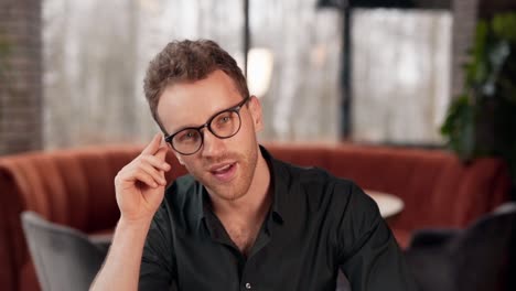 closeup portrait of a curly young man wearing glasses