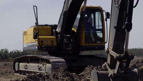 una potente grúa de pala que maneja hábilmente la carga de tierra, facilitando operaciones eficientes en el sitio de construcción
