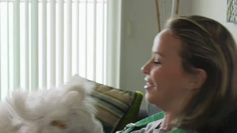 girl dog owner with small pet licking her face