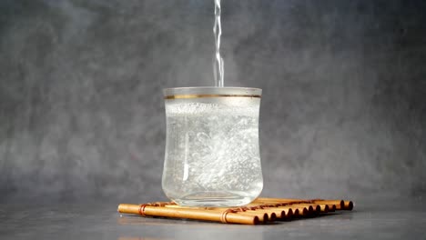 vertiendo agua caliente en un vaso ,