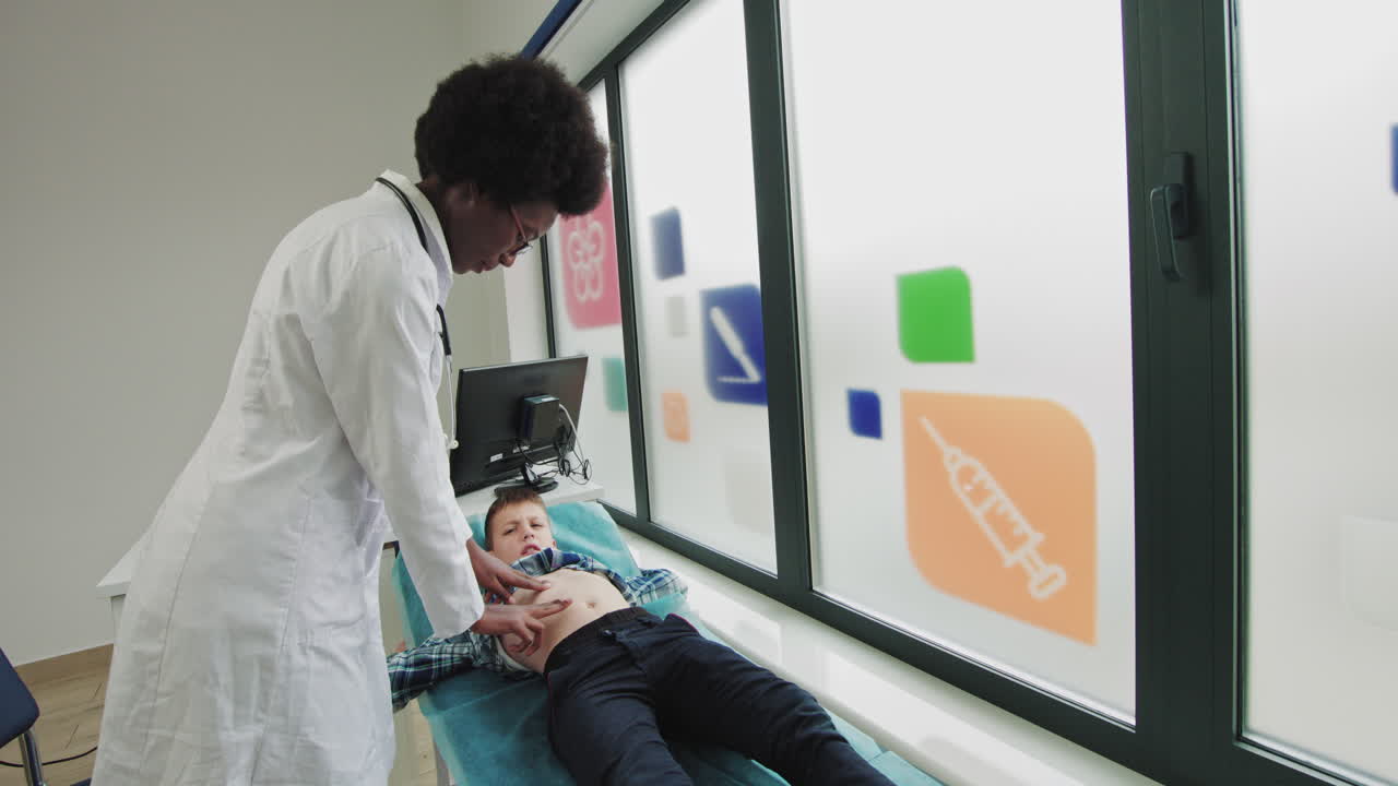 Un bambino è in ospedale e il medico esamina il dolore addominale del bambino. Specialista medico
