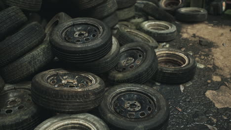 discarded tires stacked in a junkyard during an overcast afternoon