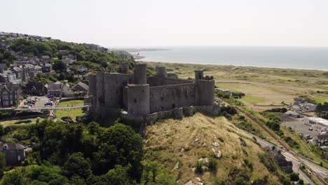 harlech castle in north wales, gwynedd, uk, shot by drone to show proximity of the castle against the town and coast