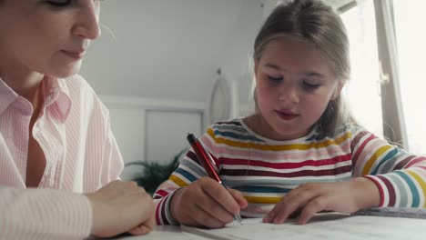 madre ayudando a su hija a hacer la tarea