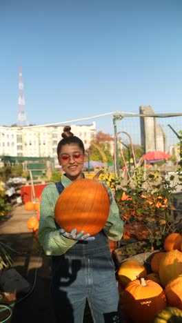 woman holding a pumpkin at a fall market