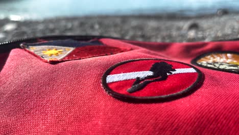 Red-Eastpack-style-Bag-With-Scuba-Diving-Flag-Patch,-Philippines-Flag-by-the-seaside