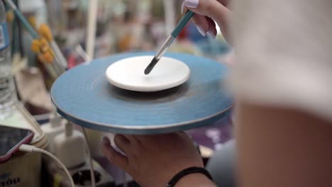woman painting pottery on a wheel
