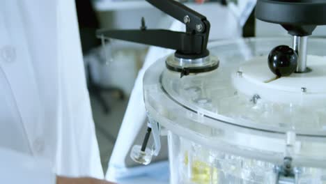 científico masculino que usa una máquina centrífuga en el laboratorio 4k