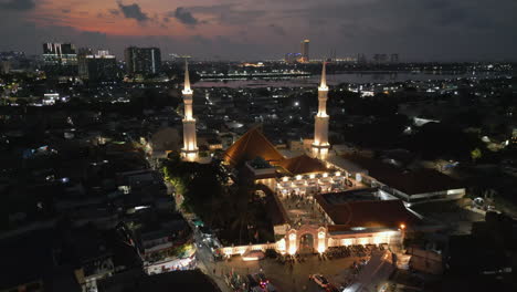 aerial view of a beautifully lit mosque at night in a city