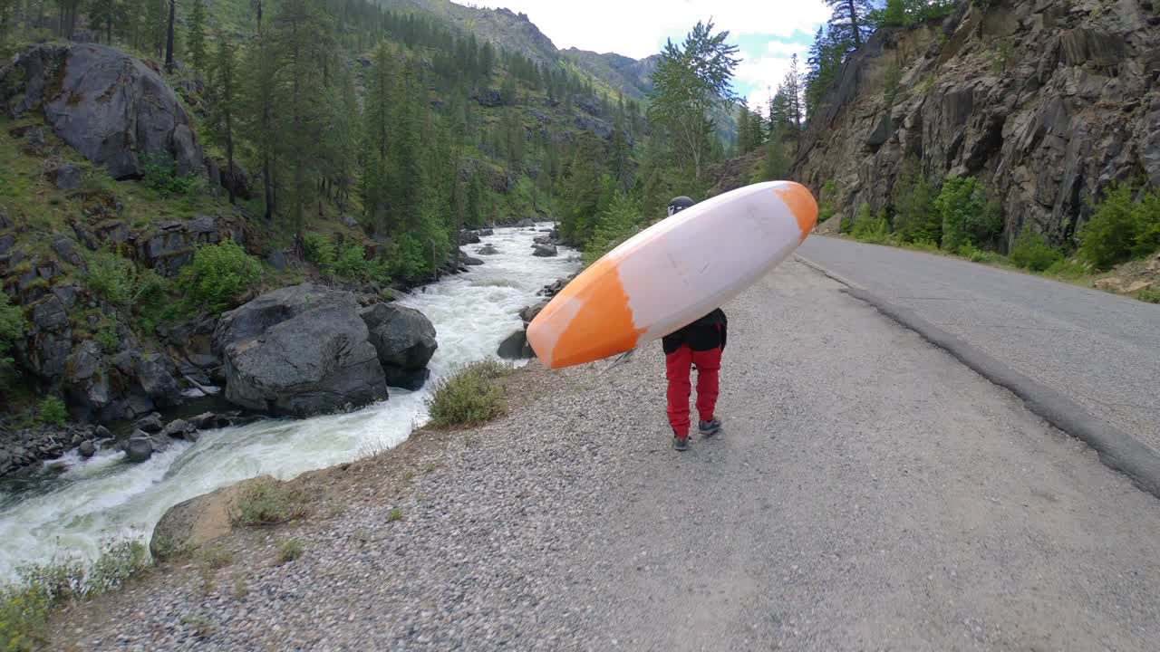 человек, несущий каяк вверх по речной дороге медленное движение