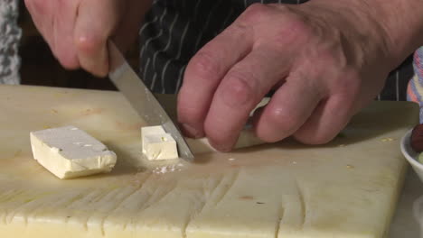 chef cutting feta cheese