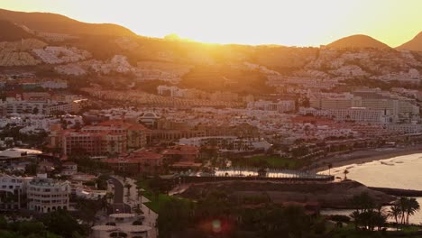 golden sunrise illuminates costa adeje’s resorts and sandy beaches by the ocean
