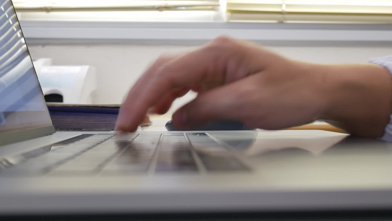 las manos de una mujer de negocios trabajando y escribiendo en una computadora portátil.