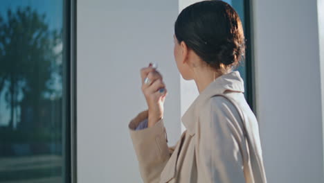 Mujer-Tomando-Auriculares-Inalámbricos-Mirando-El-Reflejo-De-La-Ventana-Al-Aire-Libre.-Chica-Con-Estilo