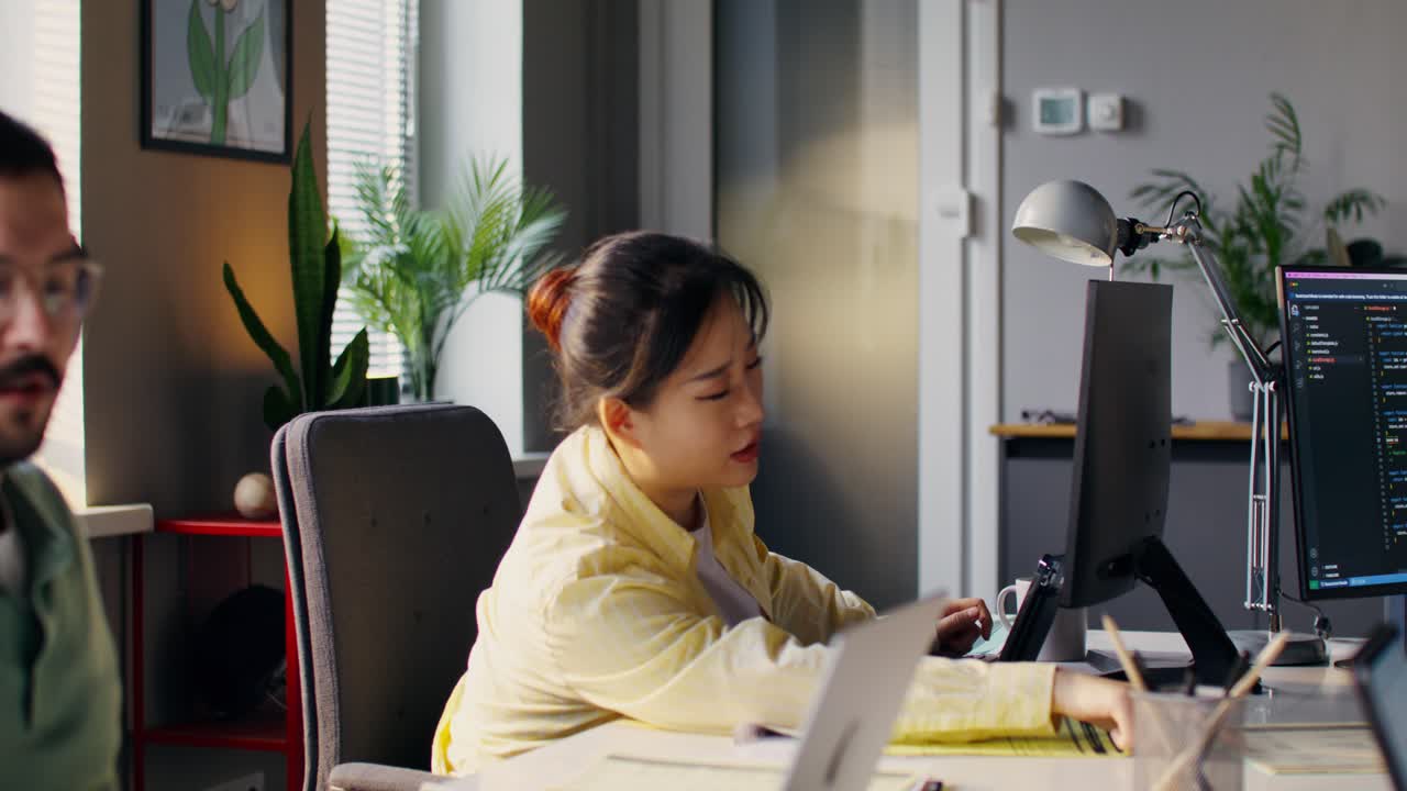 Two colleagues working on a project in a modern office