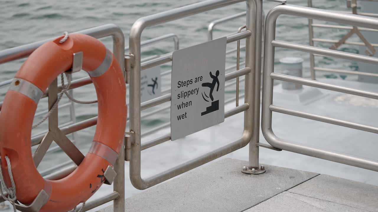 A life preserver and slippery steps sign on a boat